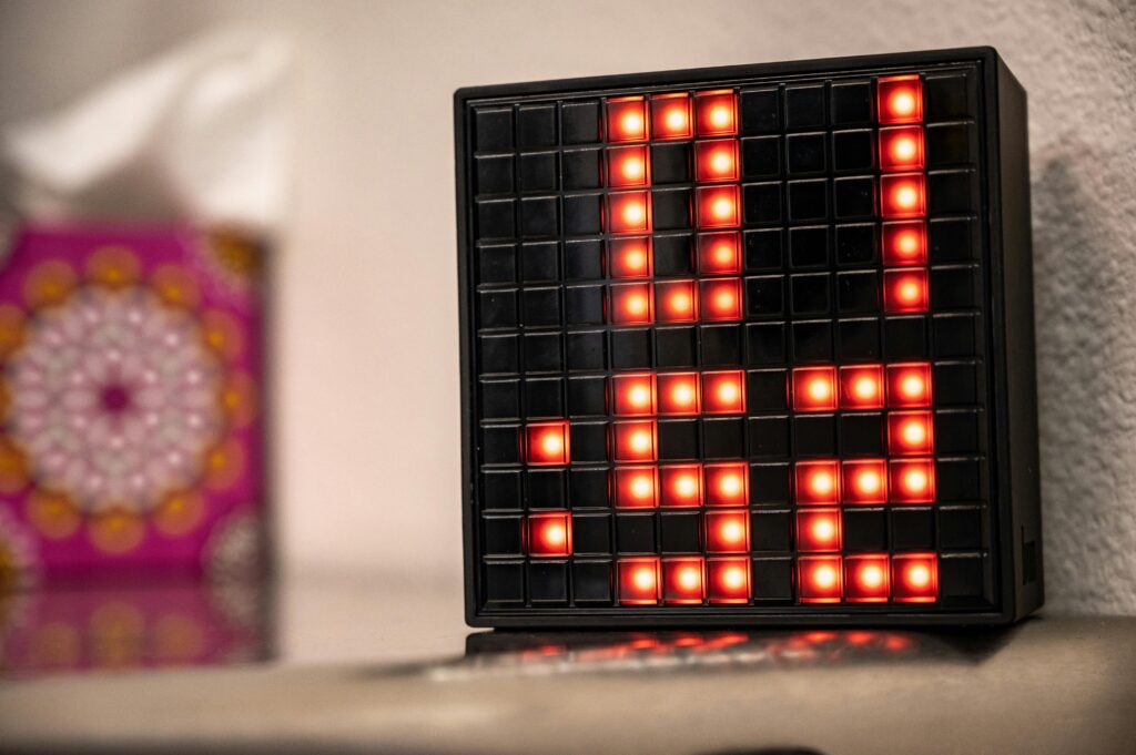 Close-up of a digital clock showing 01:52 with red LED lights, creating a modern and illuminated look indoors.